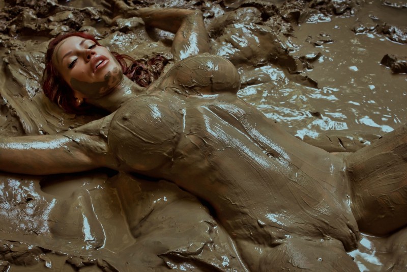 Naked women bathe in mud